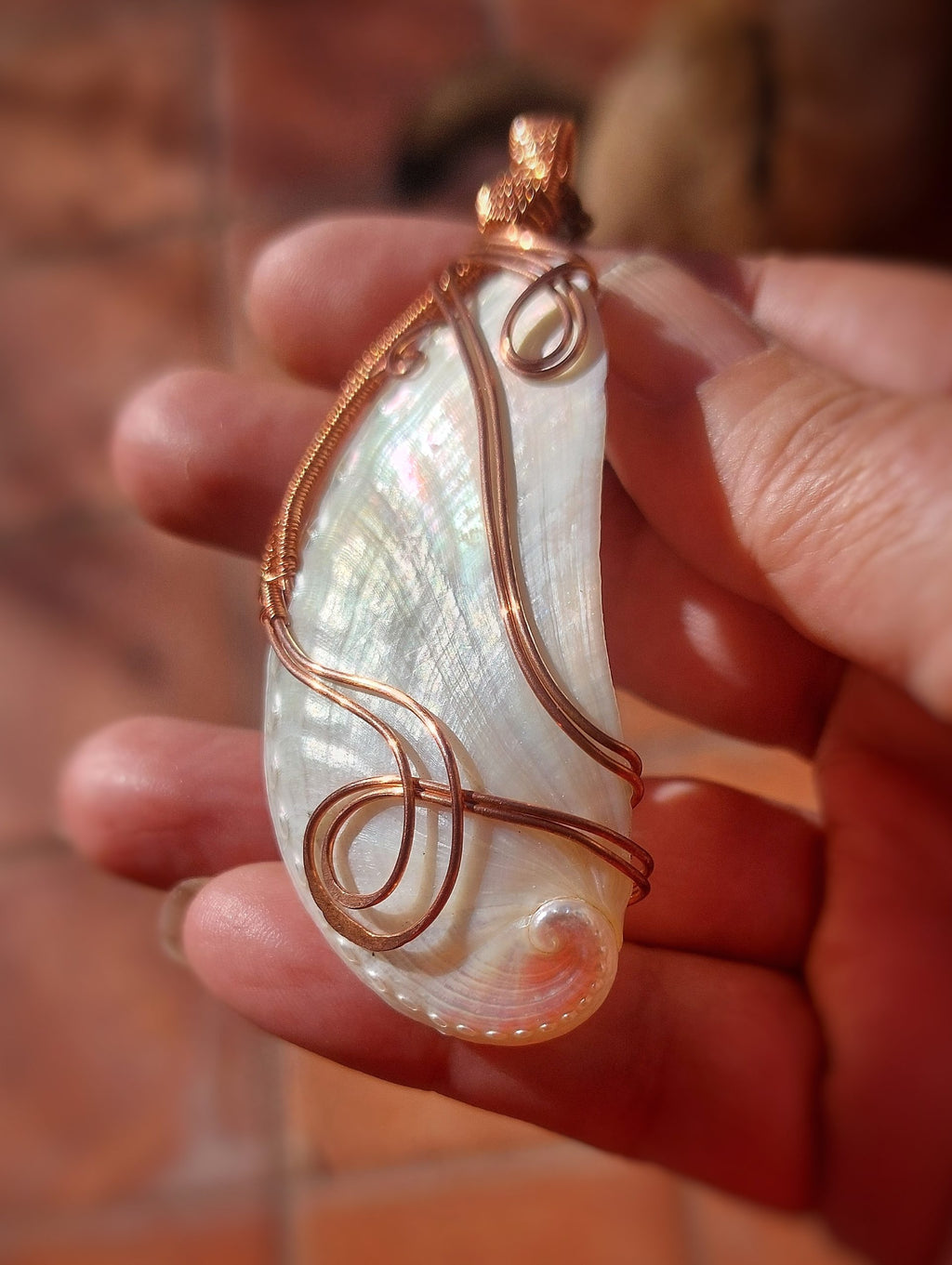 White mother of pearl shell pendant wrapped in copper wire