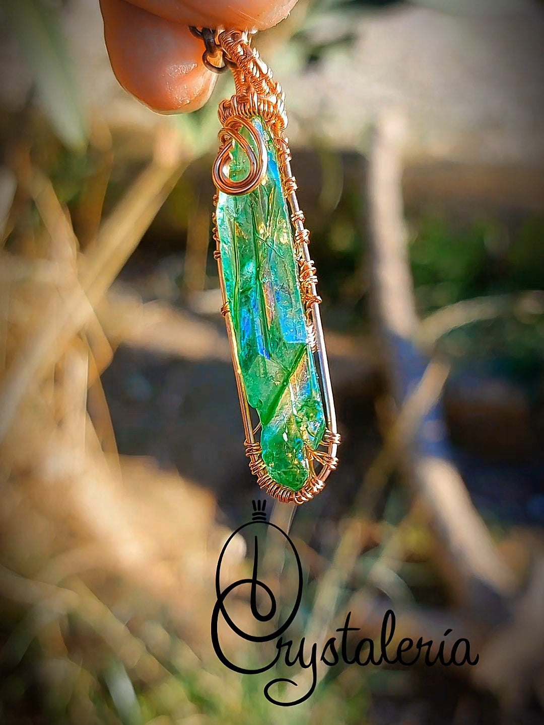 Handcrafted Titanium Aura Quartz crystal pendant on natural background