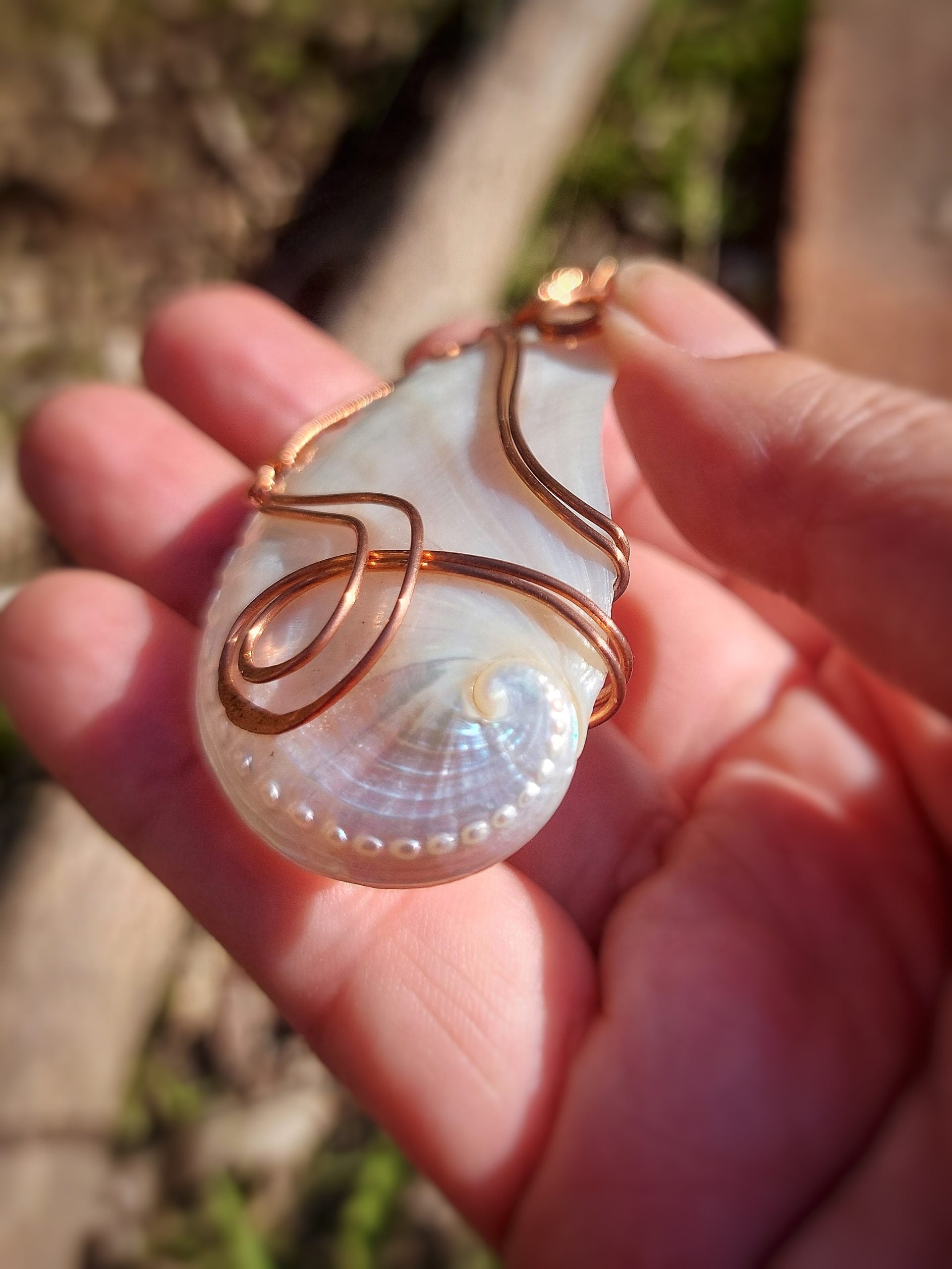 Close-up of mother of pearl guardian pendant in hand