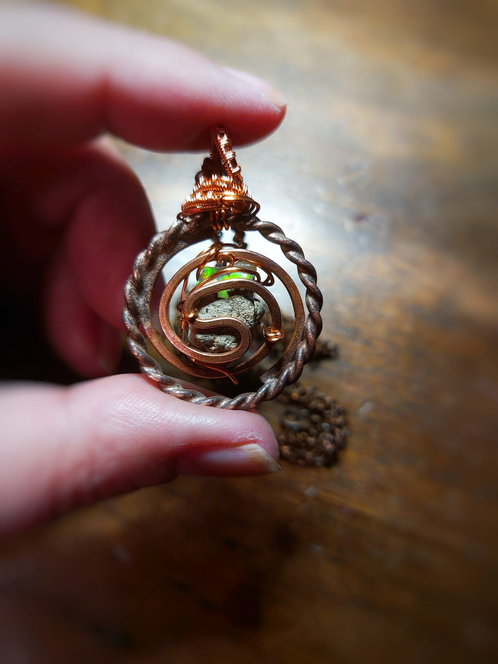 Close-up of opal stone inside spiral Tesla coil pendant with chain