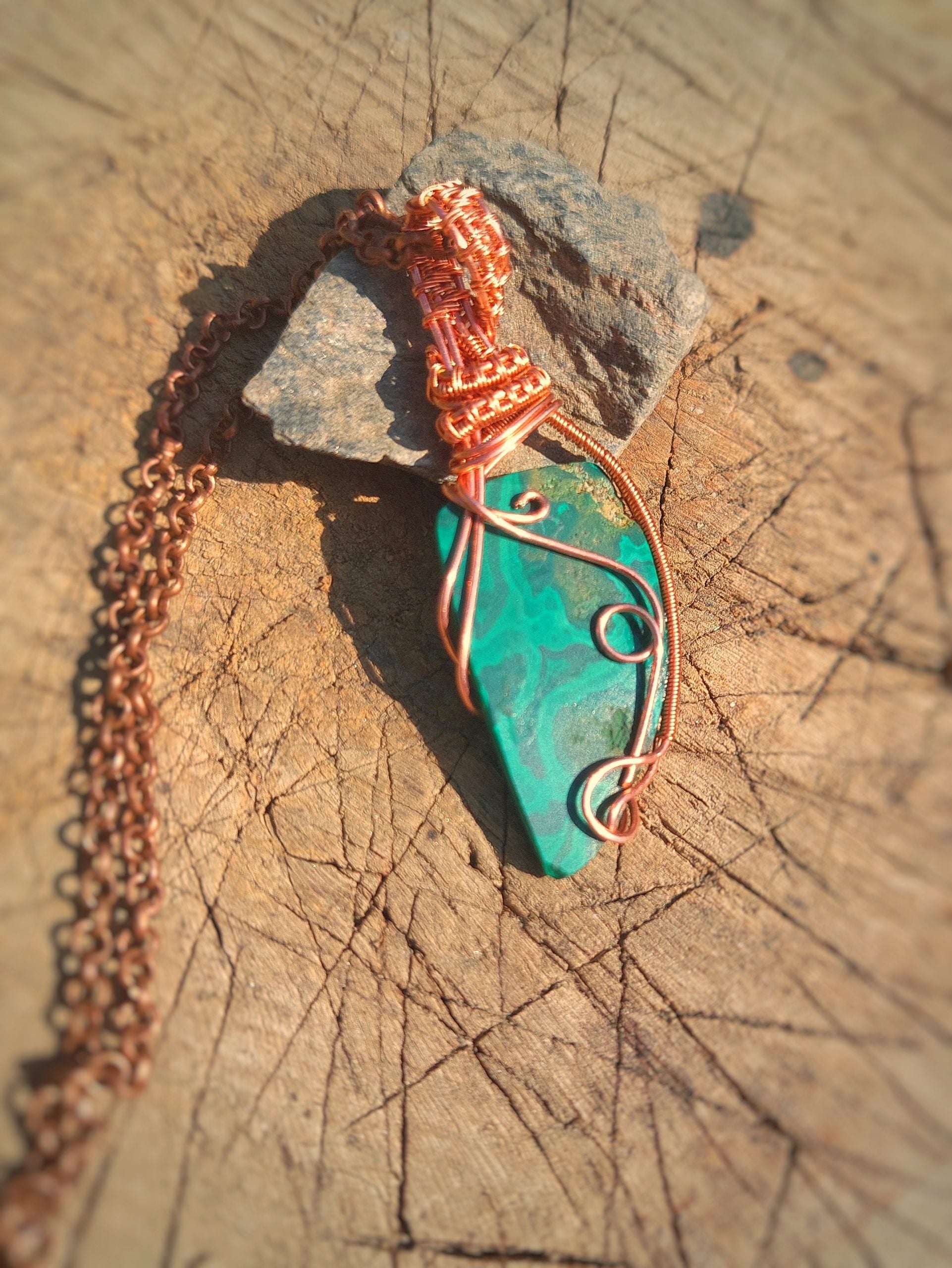 Close-up of natural malachite crystal pendant with copper wrapping