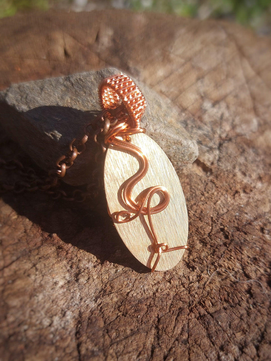 Back view of golden obsidian copper wrapped pendant showing wire pattern and bail