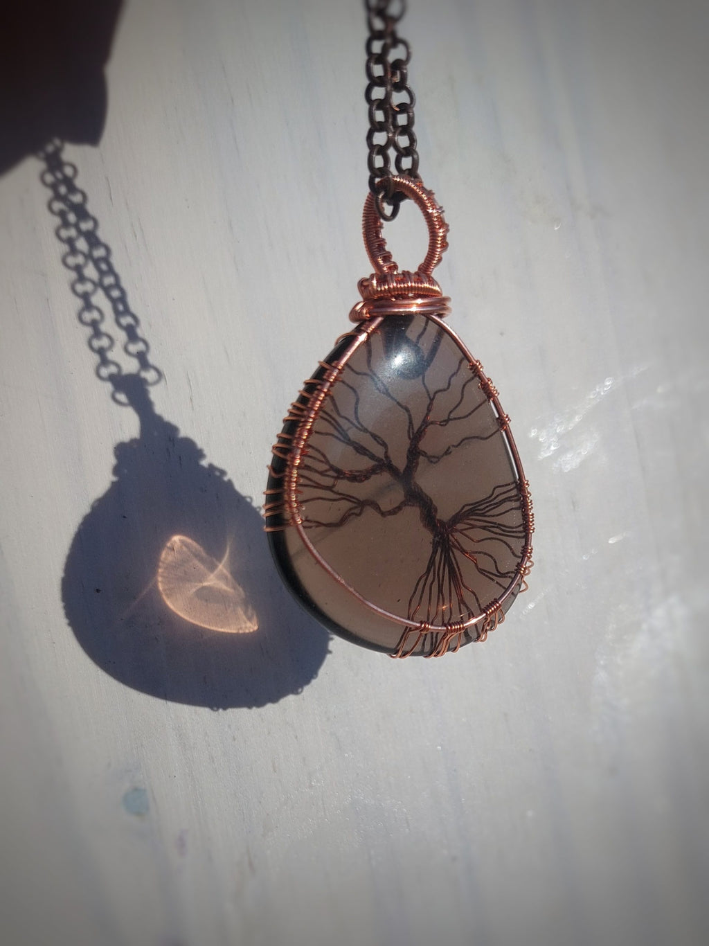 Side angle of smoky quartz copper wrapped Tree of Life pendant
