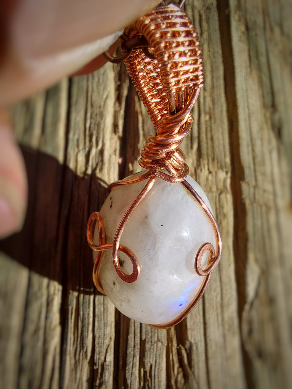 Moonstone pendant side angle with copper swirl detail
